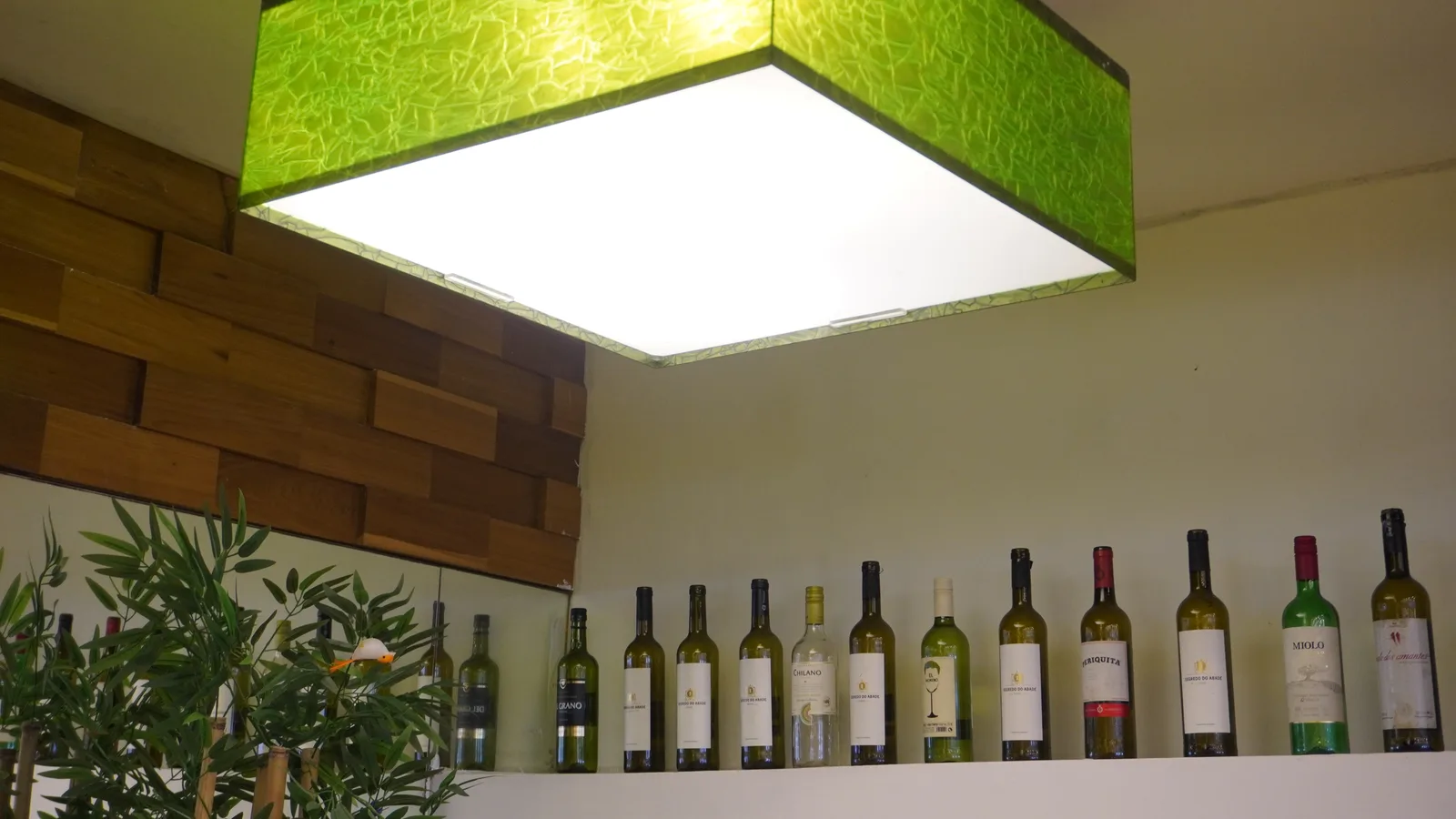 Luminária de vidro verde sobre a prateleira de vinhos do Fogão de Ouro
