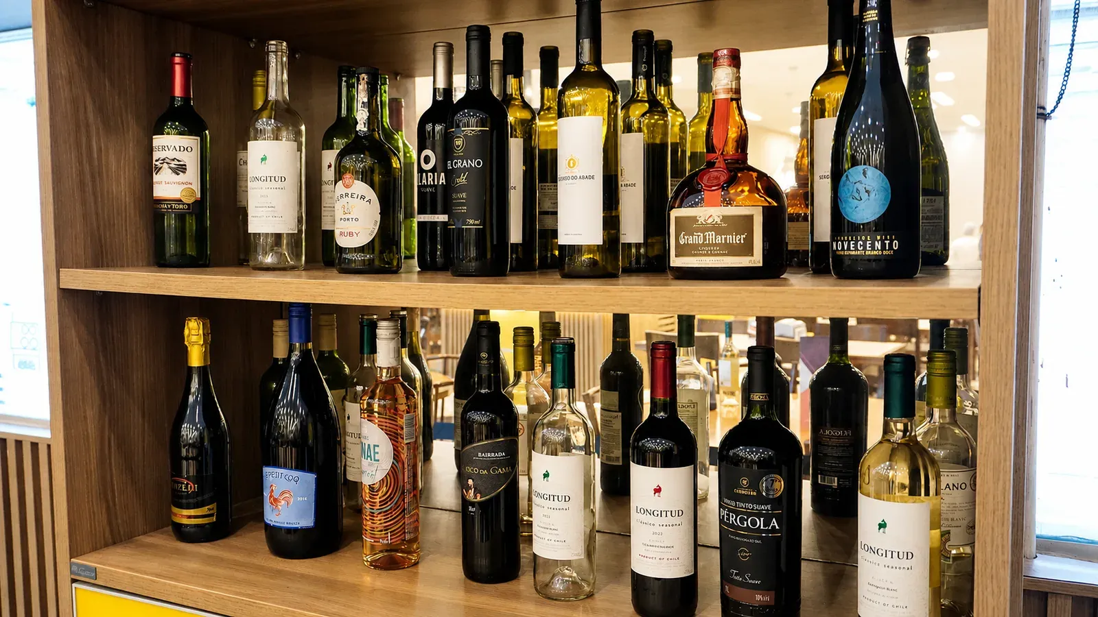 Adega do Fogão de Ouro, com garrafas de vinho tinto, branco e espumante nas prateleiras